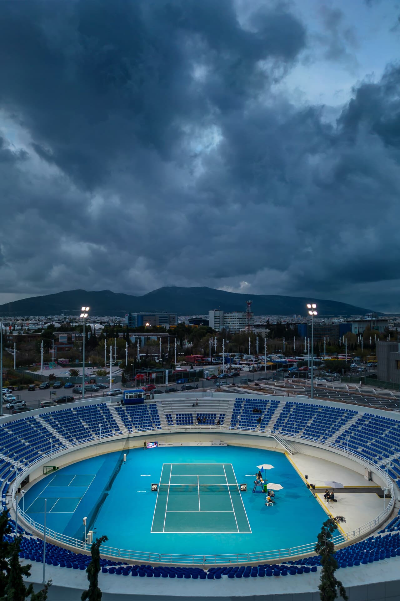 OAKA Centre Court interior after the 2025 refurbishment — blue seating, blue DecoTurf court, empty bowl.