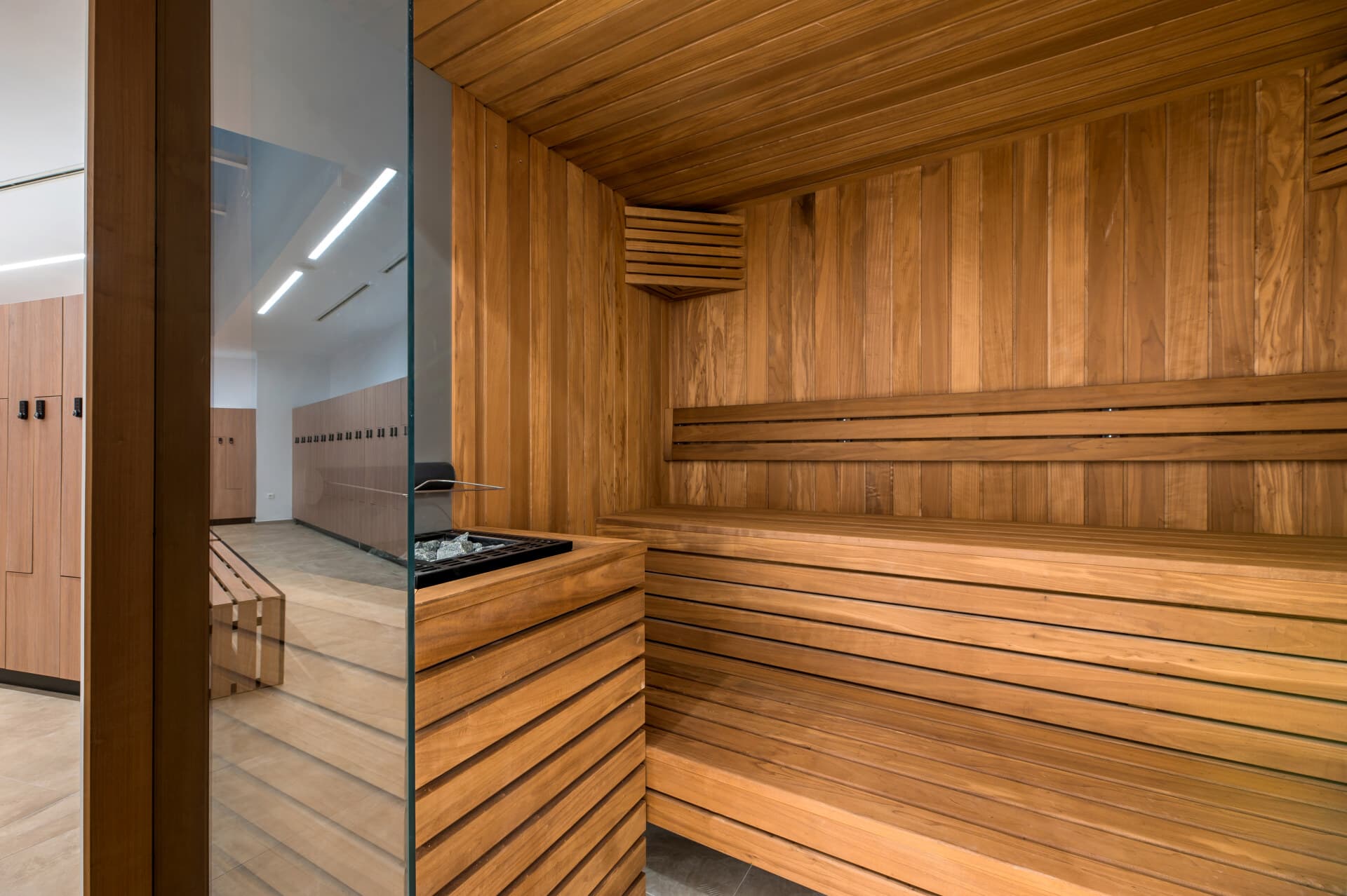 Player locker room interior with wood paneling and bench seating, OAKA 2025 refurbishment.